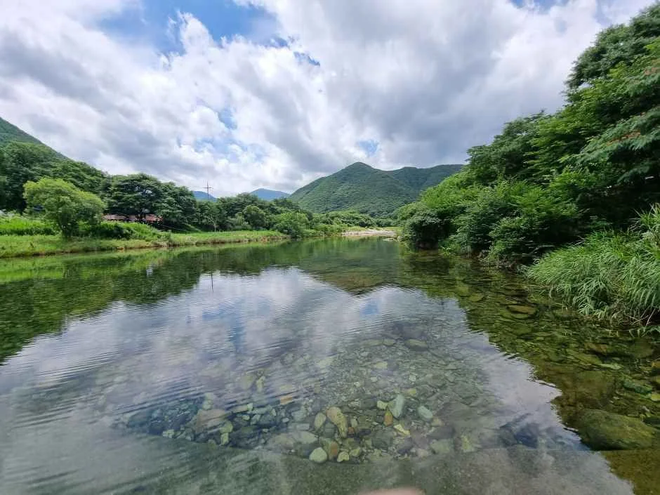 산자락 사이로 물이 고인 계곡과 구름이 보이는 풍경