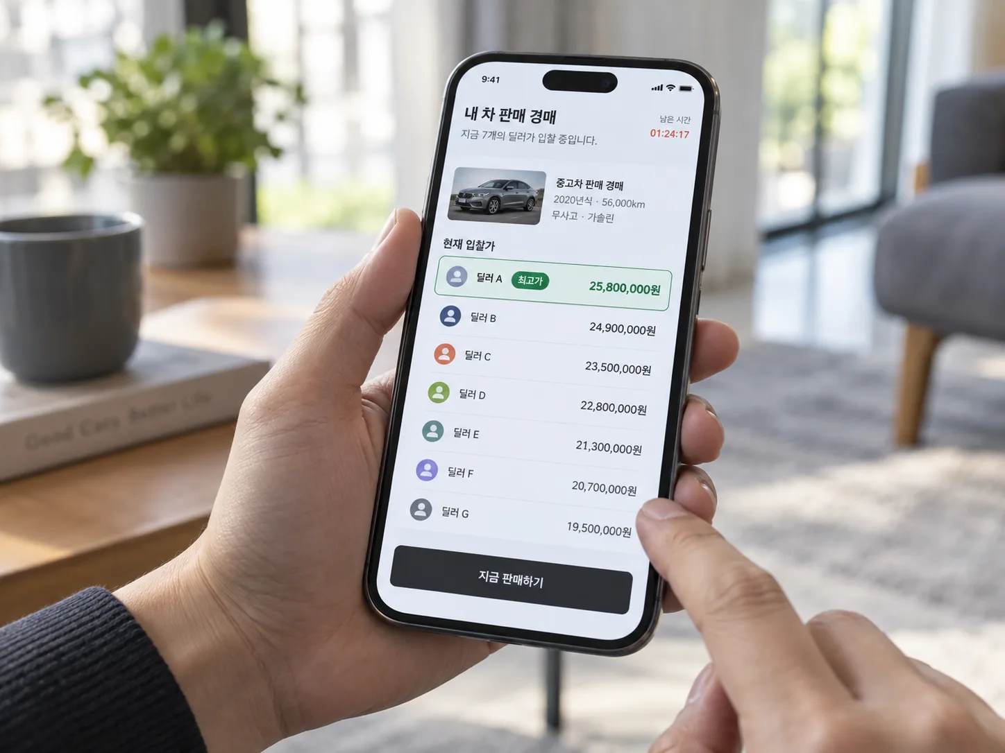 한 사람이 스마트폰으로 중고차 판매 경매 앱 화면을 들여다보는 클로즈업. 화면에는 여러 딜러의 입찰 금액이 위에서부터 순위대로 나열돼 있고 최고 입찰가가 초록색으로 강조돼 있다