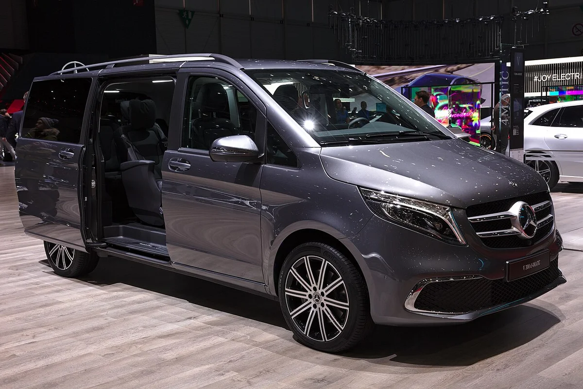 제네바 모터쇼 전시장에 선 회색 메르세데스-벤츠 V 300 d 4MATIC 전측면, 앞 슬라이딩 도어 쪽이 열려 있다