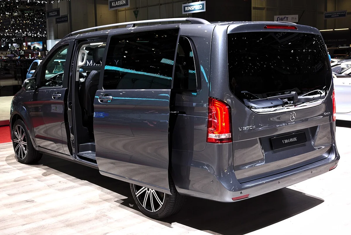 제네바 모터쇼 전시장에 선 회색 메르세데스-벤츠 V 300 d 4MATIC 후측면, 슬라이딩 도어가 열려 있다