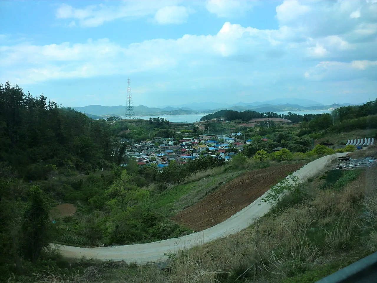 완도 신지면 송곡리 일대의 야산과 해안 마을, 저 멀리 보이는 바다