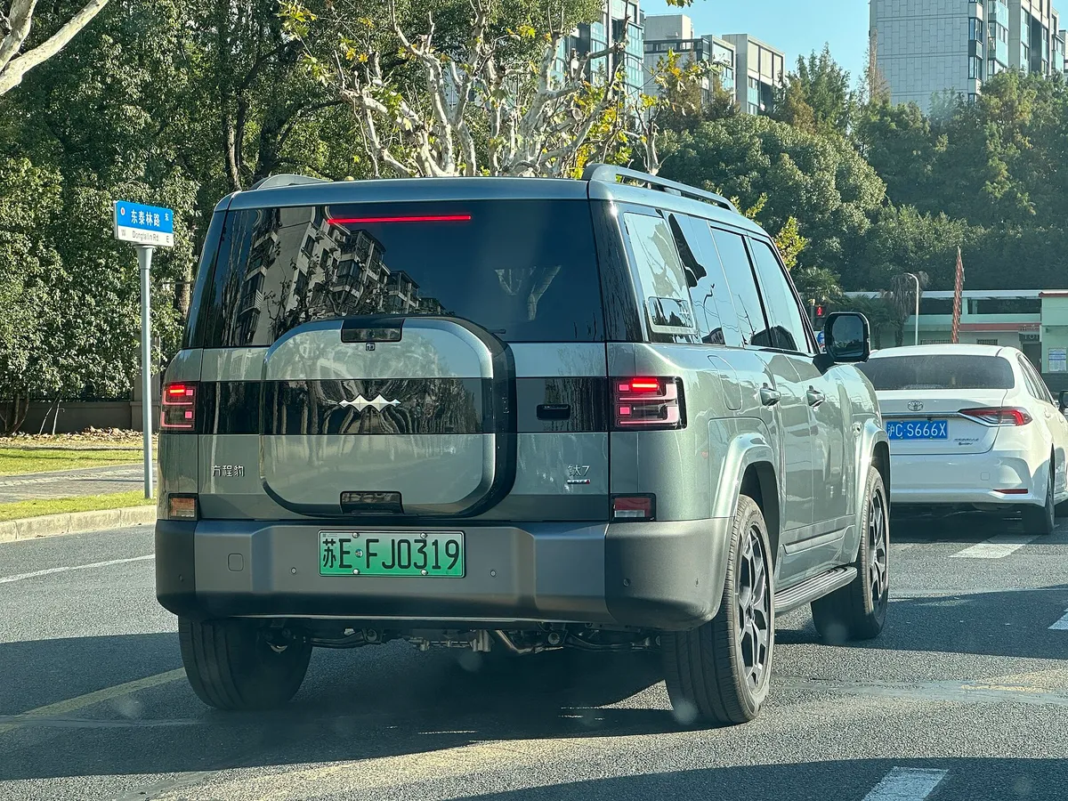 회녹색 방청바오 Ti7 SUV가 중국 도로변에 서 있는 뒷모습, 후면 스페어타이어 커버 형태의 테일게이트가 보인다