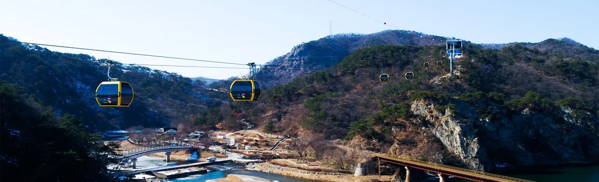 노란색 곤돌라 캐빈이 협곡을 가로질러 소금산 정상부로 올라가는 소금산 케이블카 전경