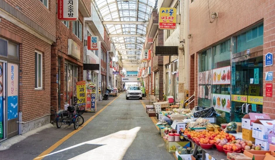 지붕이 덮인 시장 골목과 양쪽에 늘어선 점포