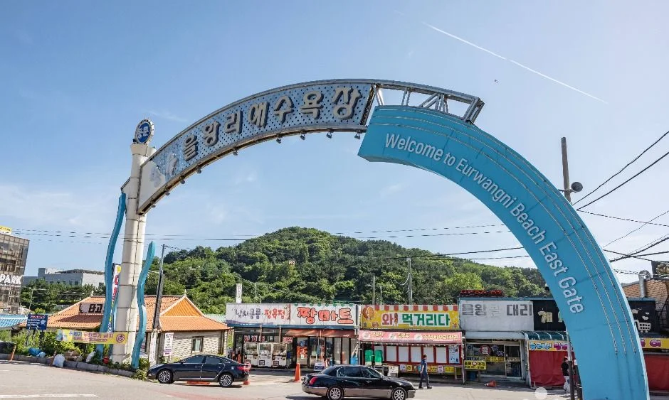 을왕리해수욕장 이름이 적힌 파란 아치형 입구와 주변 상가