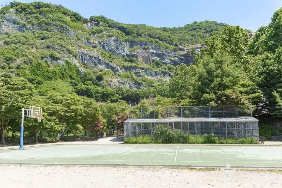 용마산 암벽 아래 용마폭포공원의 농구장과 체육시설